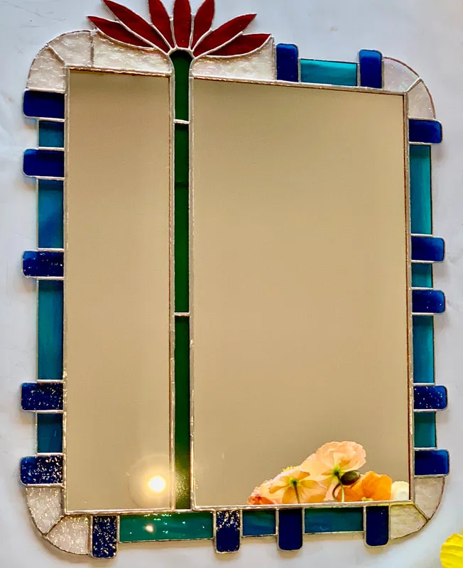 A stained glass mirror frame (by Sallie Butterfield), an abstract featuring a single flower